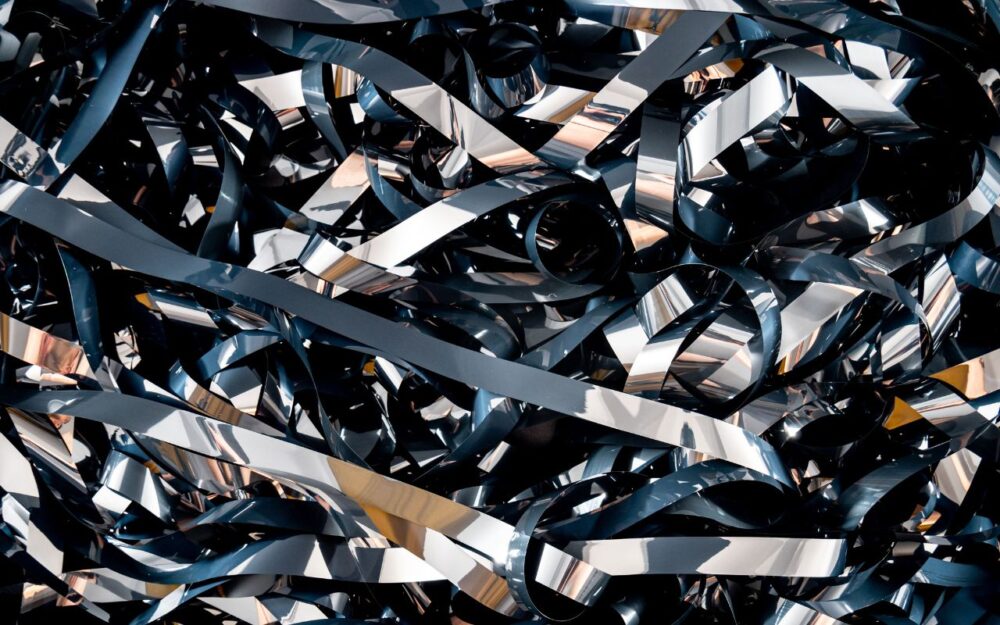 A detailed close-up of tangled magnetic tape ribbons creating a complex abstract pattern.