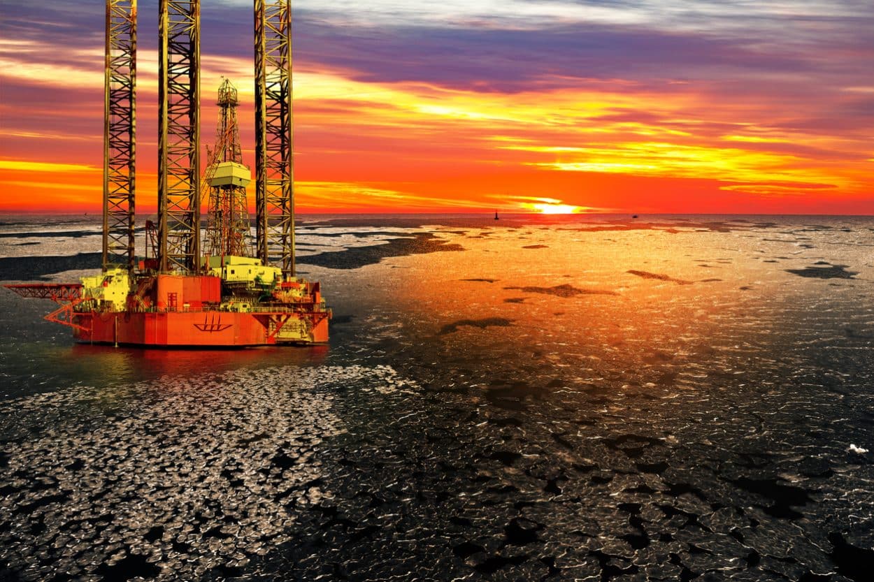 Offshore oil and rig platform in sunrise on frozen sea/ iStock